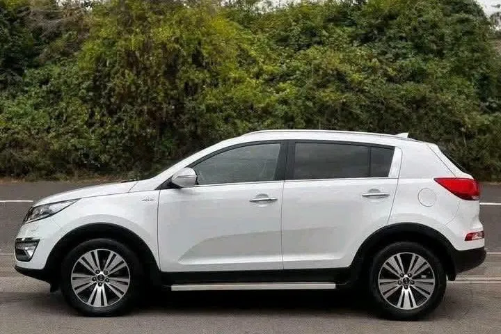 White Kia Sportage KX-4, nearside profile showing alloy wheels and side steps